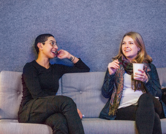 Image of two women talking on a couch